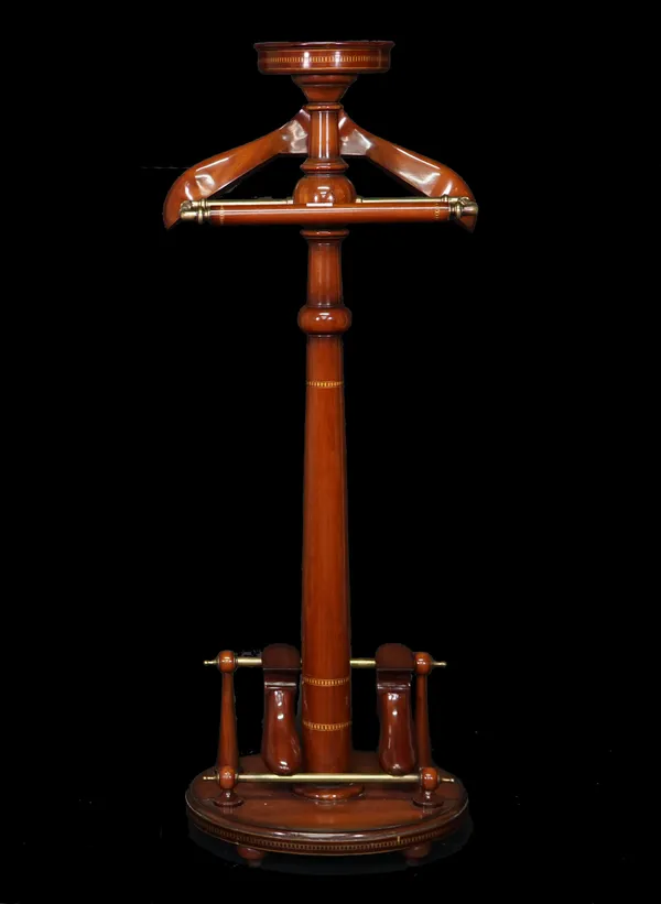 An Edwardian style inlaid mahogany and brass valet stand, with circular plinth base on bun feet, 130cm high.