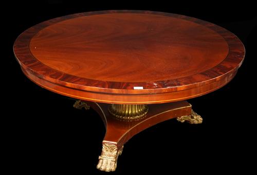 A Regency style mahogany circular low centre table on trefoil base and giltwood claw feet, 122cm wide x 53cm high.