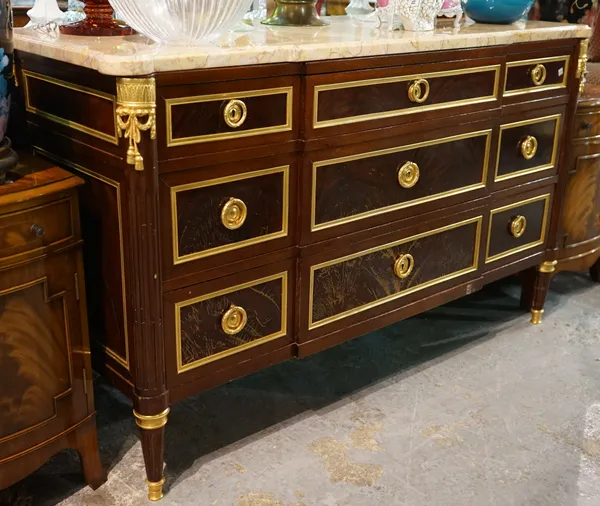A Louis XVI style mahogany and ormolu mounted marble topped commode on fluted tapering supports, 138cm x 85cm high.