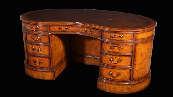 A modern mahogany kidney shaped pedestal desk with eight drawers and opposing cupboard base, with brown leather inset top, 180cm wide.