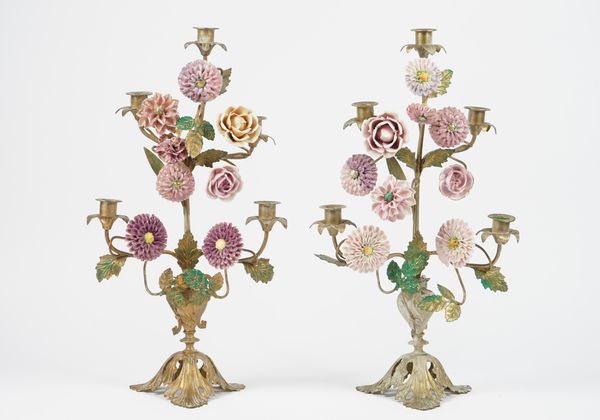 A pair of modern gilt metal five branch candelabra decorated with porcelain headed flowers issuing from an urn, over a pierced triform base, 52cm high