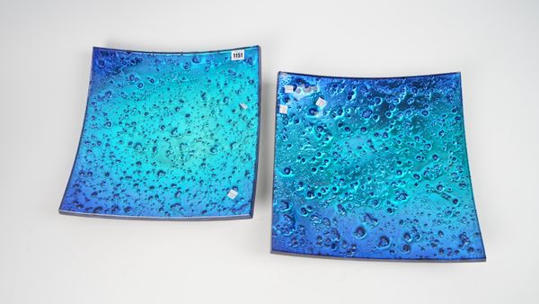 A pair of modern metallic blue glass dishes, of square convex form, unsigned, 38.5cm wide.