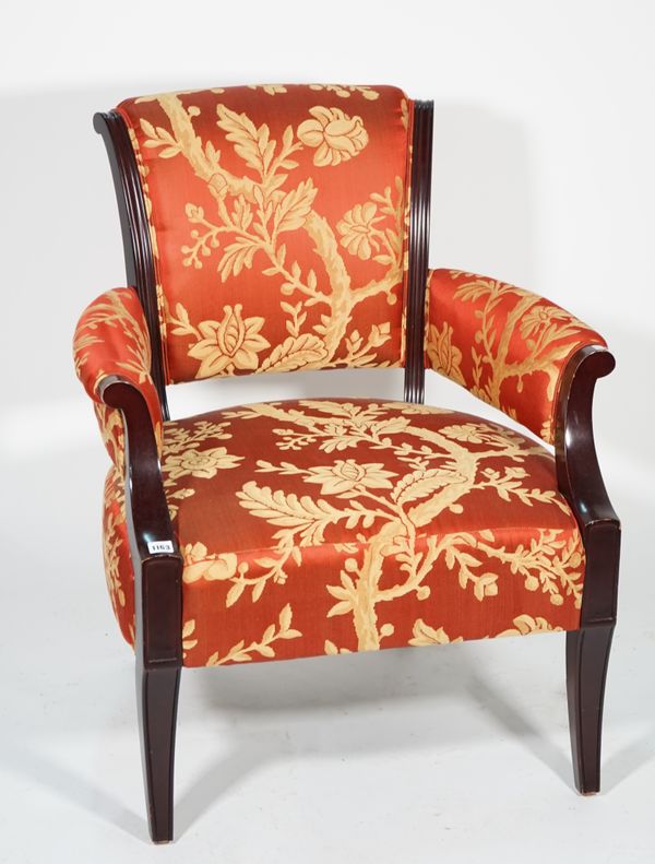 A modern ebonised hardwood low open armchair, with red and gold foliate upholstery, 75cm wide x 87cm high.