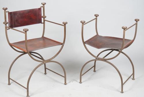 A set of four wrought iron and brown leather open armchairs with 'X' frame supports, 55cm wide x 88cm high and four further, lacking backs, (8).