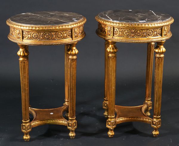 A pair of Regency style giltwood marble topped occasional tables, on fluted tapering supports, 48cm diameter x 77cm high, (2).