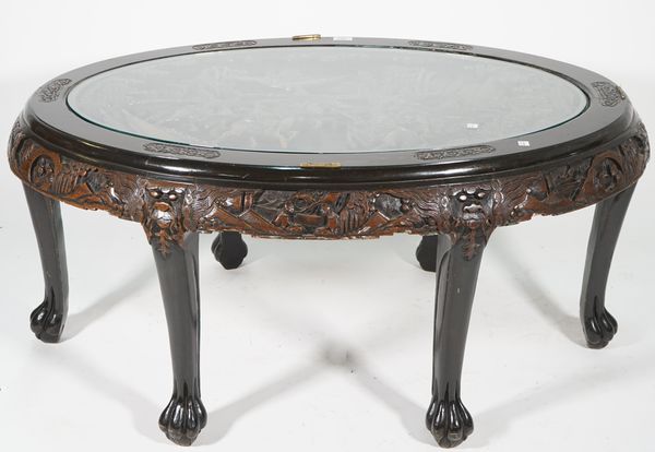 A modern Chinese carved hardwood oval coffee table, with inset glass top, 110cm wide x 50cm high.