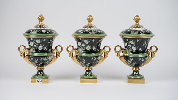 A set of three Dresden modern porcelain vases and covers, each foliate decorated against a black and green banded ground with gilt scroll twin handles