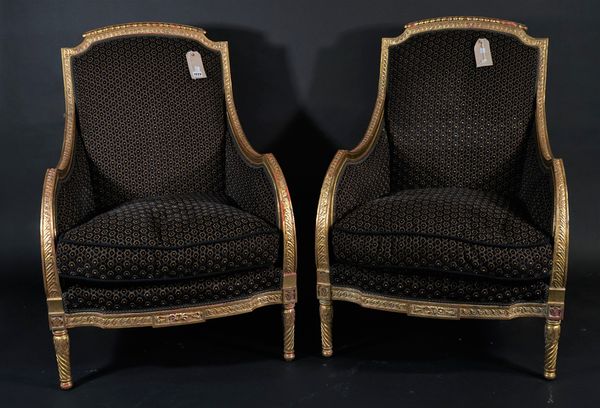 A pair of Louis XV style giltwood bergere armchairs, with brown/ black honeycomb pattern upholstery, spiral twisted tapering supports, 68cm wide x 101