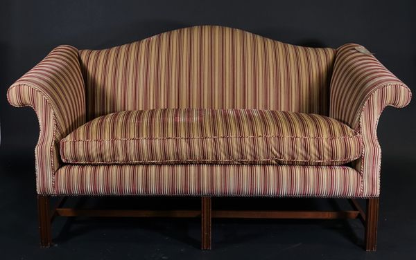 A George III style mahogany framed arch back sofa, with rollover arms and gold and maroon striped upholstery, 180cm wide x 90cm high.