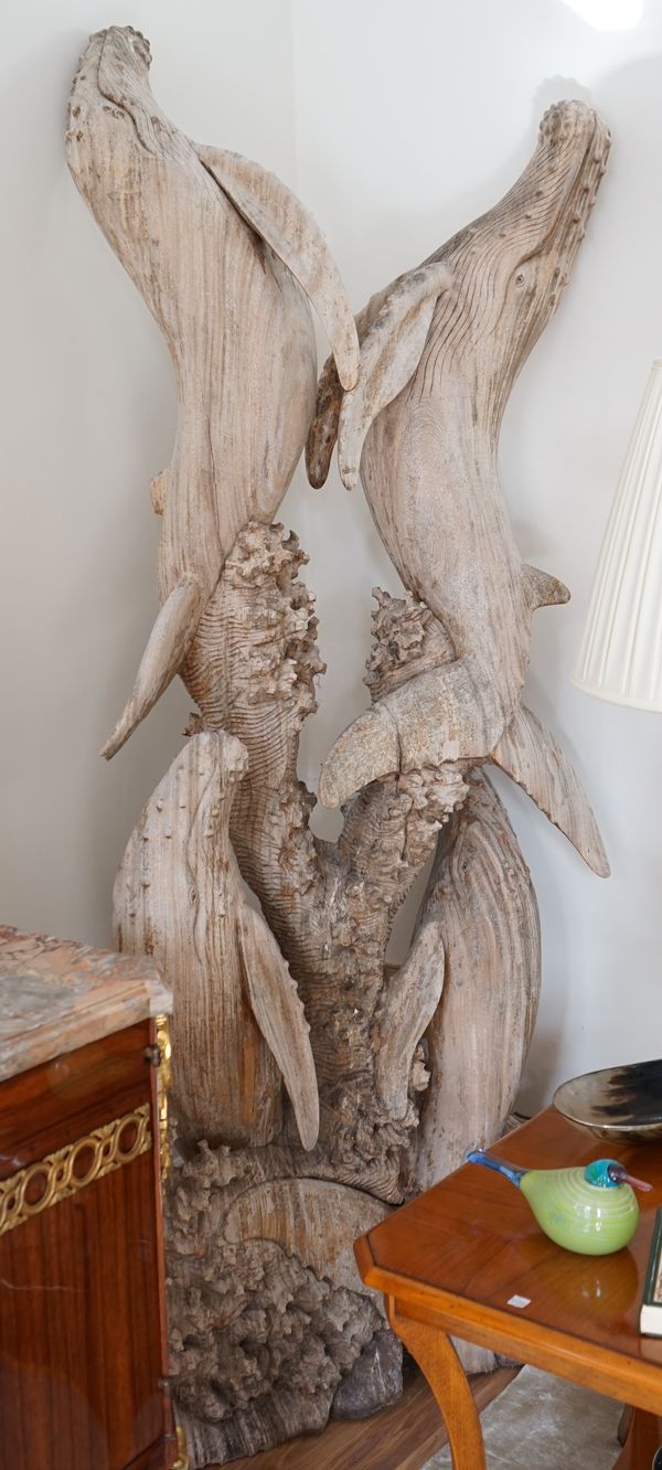 A carved drift wood style group of whales, 205cm high.