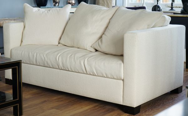 A cream upholstered two seater sofa, 177cm wide x 70cm high.