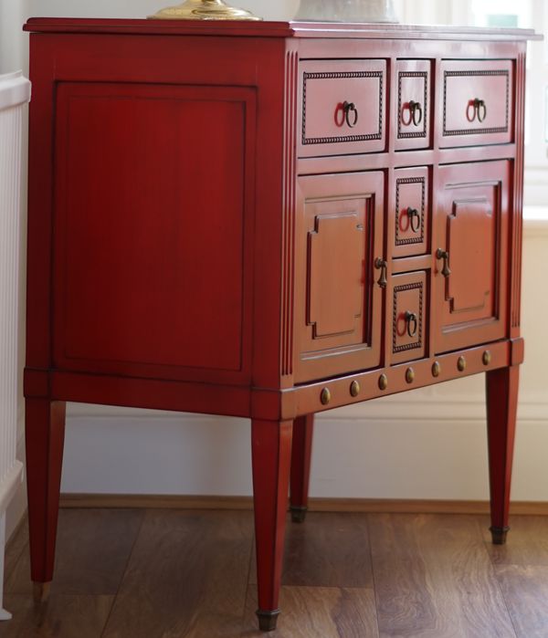 A Louis XVI style red lacquer commode, with an arrangement of various drawers, 91cm wide x 86cm high.