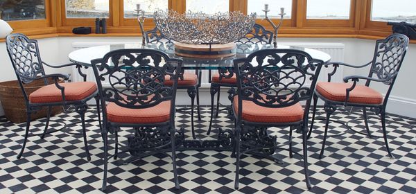 A modern grey painted glass topped oval table, 175cm wide x 74cm high and eight chairs, 55cm wide x 88cm high.