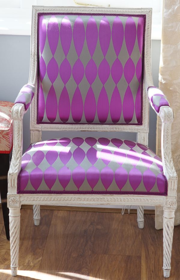 A pair of Louis XVI style white painted fauteuils, each upholstered in a pink and grey design, 58cm wide x 93cm high.