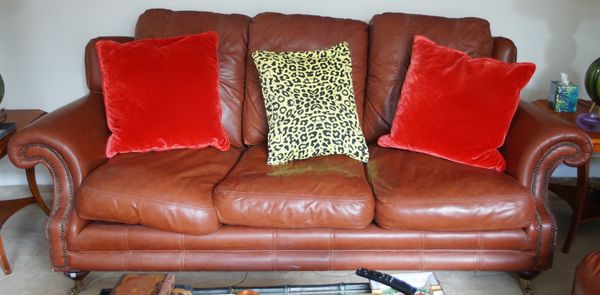 A tan leather upholstered suite, comprising; an armchair, 107cm wide x 100cm high, a two seater sofa and a three seater sofa, 228cm wide x 87cm high.