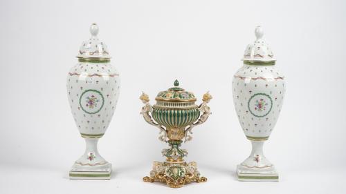 A Thomas Goode porcelain vase and cover, modern, with twin cupid handles and a shell moulded cover, gilt/green on a pierced base and lion paw feet, 30