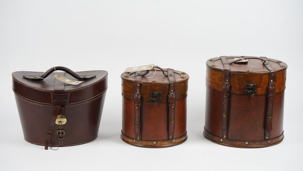 A hand made leather hat box, 35cm wide and two leather bound wooden boxes of circular form, (3).