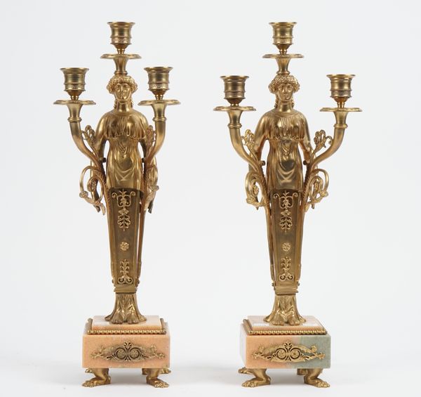 A pair of Victorian style gilt metal and marble three branch figural candelabra, each raised on a stepped square plinth and four lion paw feet, 44.5cm