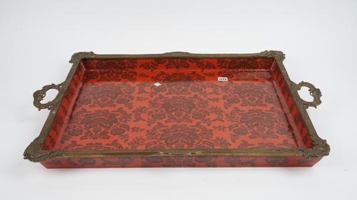 A pair of modern porcelain and gilt metal mounted, twin handled trays, each foliate decorated against a red ground, blue printed marks, 82cm wide, (2)