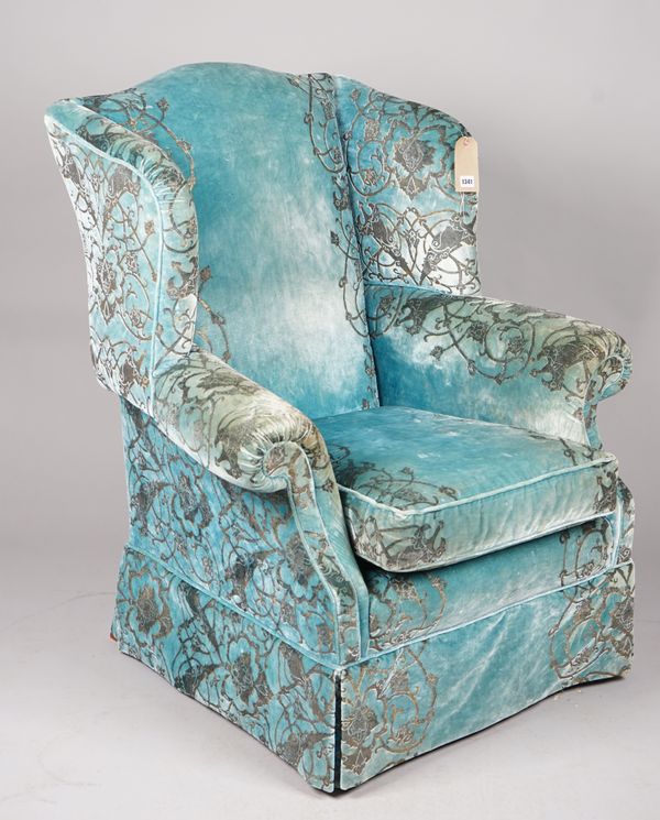 A modern wingback armchair with rollover arms and turquoise and silver foliate upholstery, 93cm wide x 113cm high.