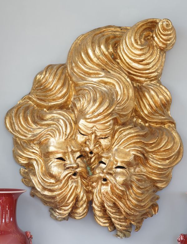 A modern gilt papier mâché wall mask formed as a god of wind, 95cm high, and another smaller, (2).