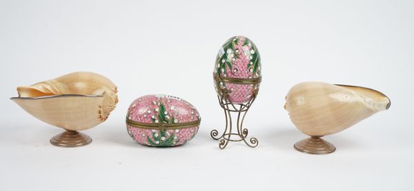 A pair of porcelain eggs formed as trinket boxes, each gilt foliate decorated against a pink ground with gilt metal mounts, one on a stand, 16cm, a pa