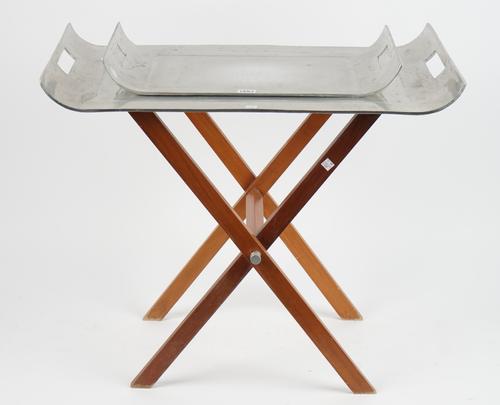A graduated pair of aluminium twin handled trays, of contemporary form on a folding hardwood stand, 71.5cm wide.