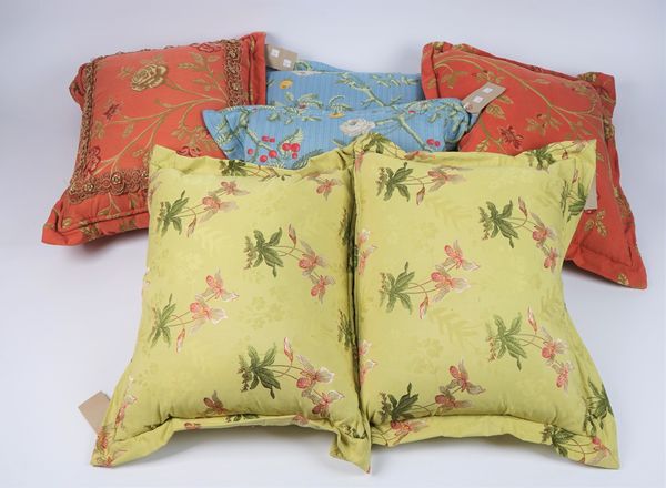 A group of six cushions, all with floral decoration, two blue, two green and two in brick red.