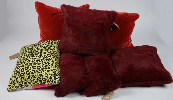 Four faux fur maroon cushions, two red velvet and one bright pink and leopard print cushion, (6).