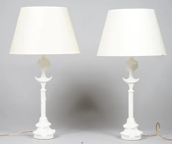 A pair of white plaster figural table lamps with white shades, each 83cm high.