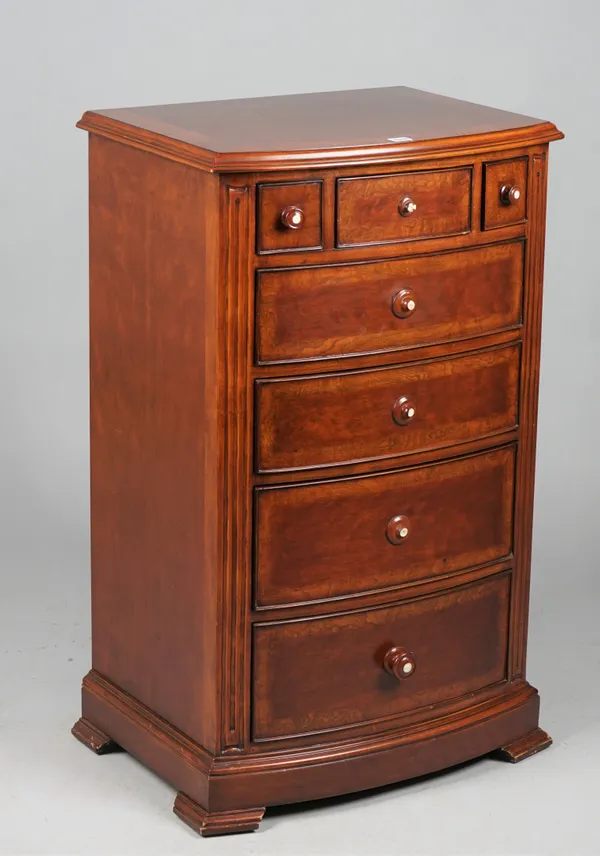 A modern mahogany bowfront tall chest of three short and four long drawers on bracket feet, 61cm wide x 102ch high, (a.f.).