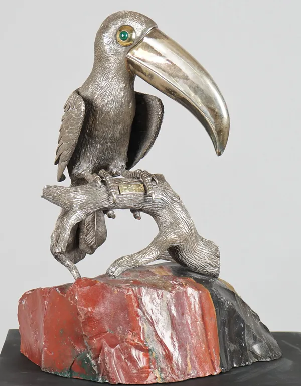 A 20th century silver model of a Toucan with malachite set eyes, resting on a rustic branch, applied with a rectangular panel, detailed 750 and engrav