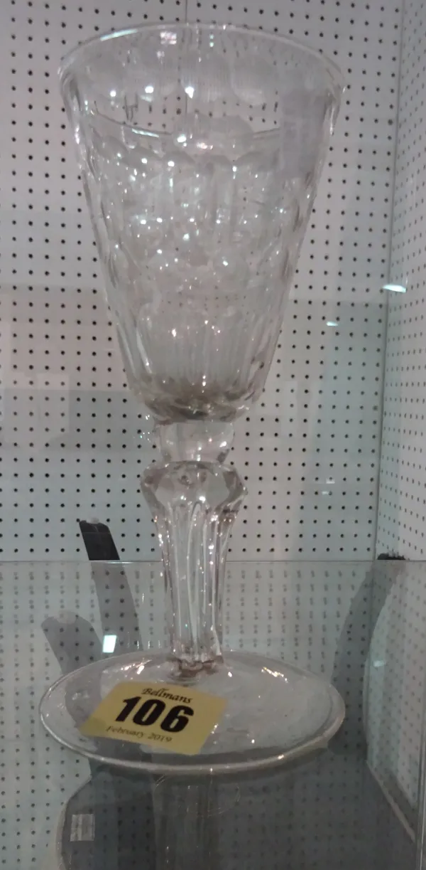 A pedestal stemmed wine glass, 18th century,  the funnel bowl cut with stylised flowers and flutes, above a moulded four-sided teared pedestal stem an