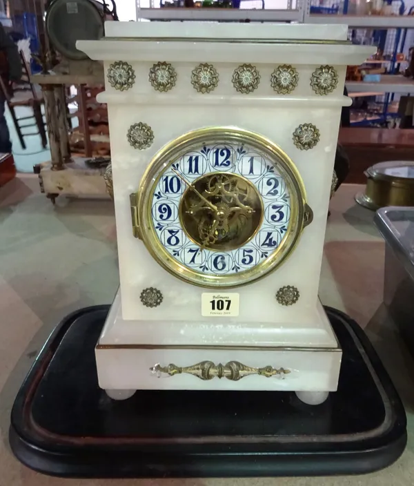 A French alabaster mantel clock, late 19th/early 20th century, with visible escapement and an Arts and Crafts style numerical chapter ring, the case f