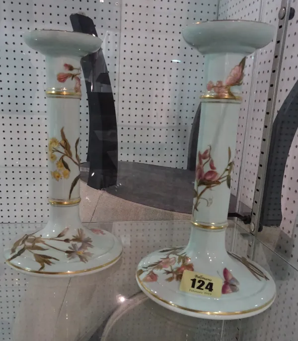 A pair of Royal Worcester porcelain candlesticks, late 19th century, each polychrome and gilt decorated against a green pastel ground, manganese print