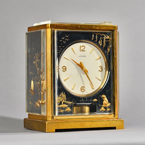 A Jaeger Le Coultre 'Marina' atmos clock, gilt decorated with Chinese landscape scenes against a black ground, serial number 111782, 23cm high. Illust