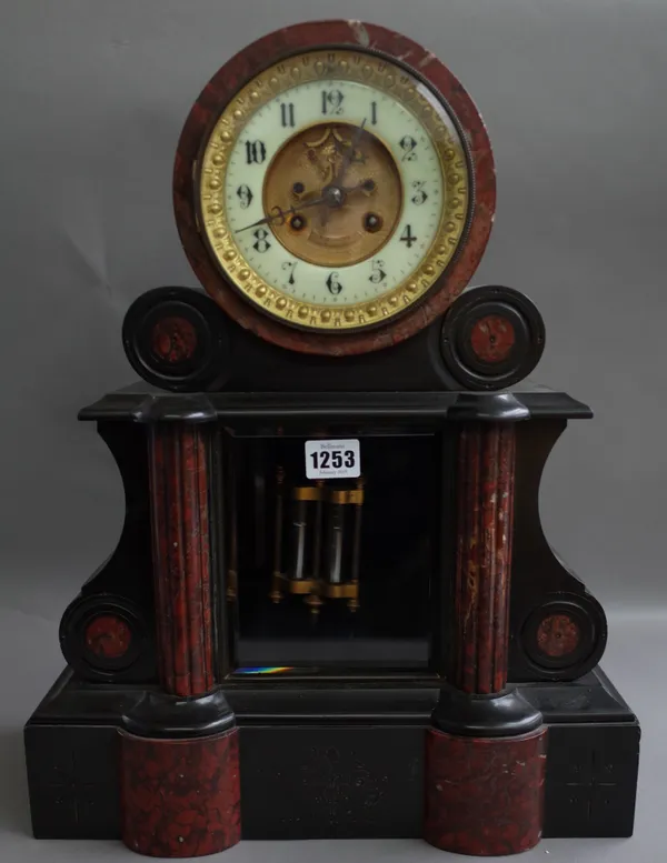 A Victorian black slate and rouge marble inlaid mantel clock, the drum case with visible brocat escapement, over a glazed pendulum aperture and plinth