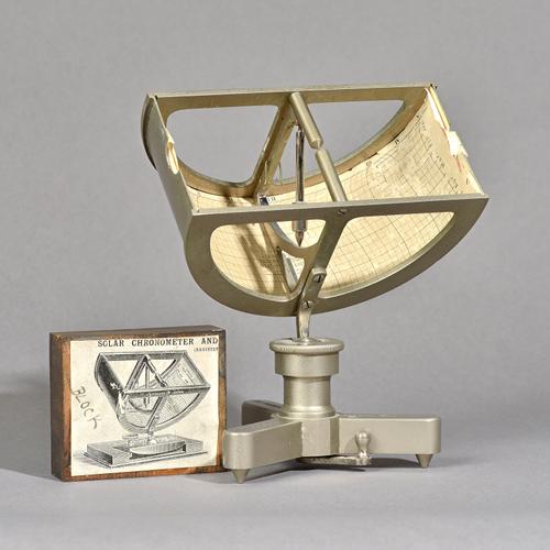 A Fergusons chronometer by J.S. Enright, 1923, with adjustable top and triform base and a wooden printing block depicting a similar chronometer, (2).