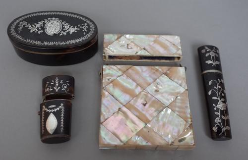 A tortoise shell and silver inlaid oval snuff box, circa. 1860 (8.5cm wide), two further tortoise shell and silver inlaid cases of oval tapering form