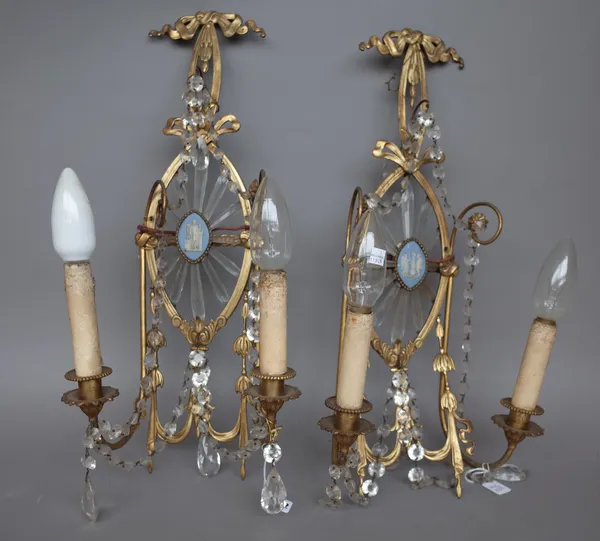 A pair of late 19th century gilt brass two branch wall appliques, each cast with bows and swags, centred with a Wedgwood jasperware plaque and hung wi