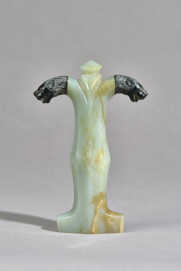 A jade dagger / sword handle with carved lions head detail to the pommel, 12.3cm.   Illustrated