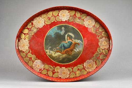 A pair of Regency tole piente oval twin handled trays, each centrally decorated with classical figures within a gilt foliate wide border against a dee