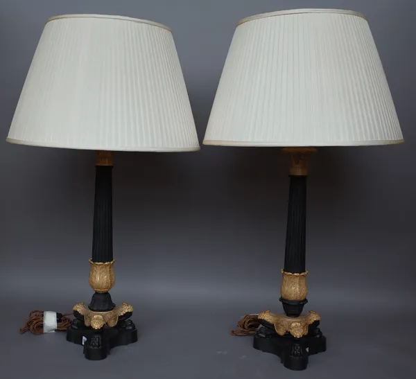 A pair of Victorian style gilt metal and bronze table lamps, modern, each of fluted column form on three lion paw feet and a triform base, 'Vaughn' la