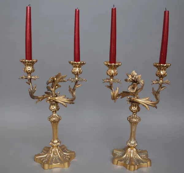 A pair of Rococo style gilt bronze twin branch candelabra, each raised on a shaped foot, 38cm high. (2)