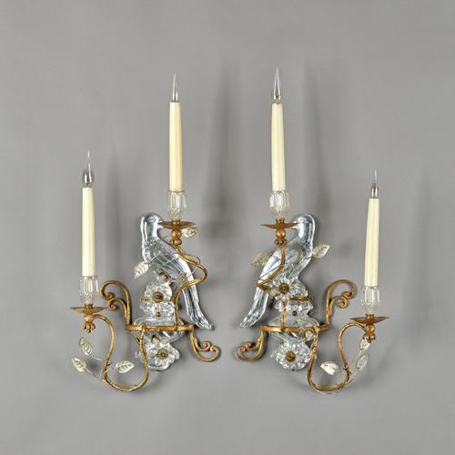 Attributed to Bagues, Paris, a pair of gilt metal and rock crystal two branch wall appliques, each with a bird over urn back plate, 60cm high overall.
