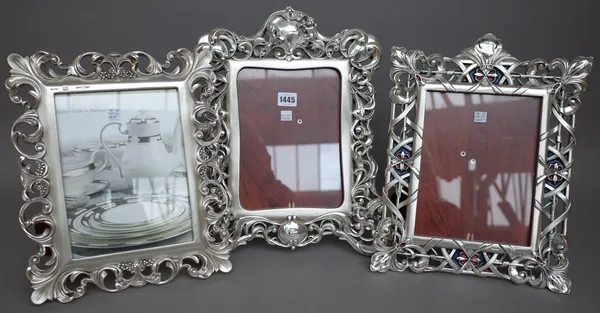 Seven Linea Argenti strutback photograph frames, each white metal with foliate pierced border, the largest 42cm x 35cm. (7)