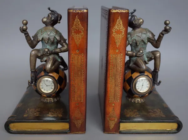 A pair of modern leather and metal mounted bookends modelled with a monkey on a globular clock and two leather books, 24cm high, four decorative porce