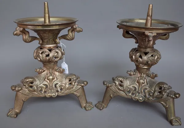 A pair of 18th century style gilt metal altar candlesticks, each relief cast with mythological creatures over a knopped central stem and pierced trifo