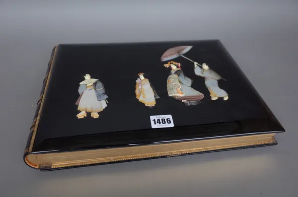A Japanese lacquer photograph album, circa 1930, with mother-of-pearl figural decoration to the front cover and gilt relief fauna and flora to the rea