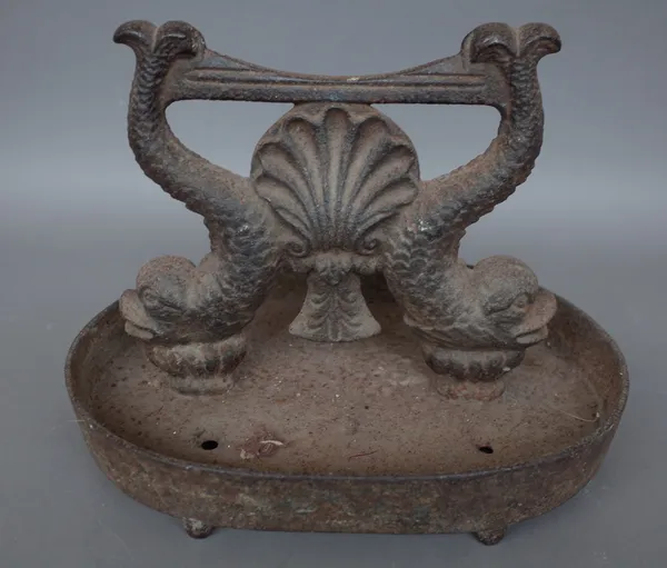 A Victorian cast iron boot scraper, the foot plate raised on twin mythological fish on an oval dished base and four feet, 36cm wide and a stone sphere